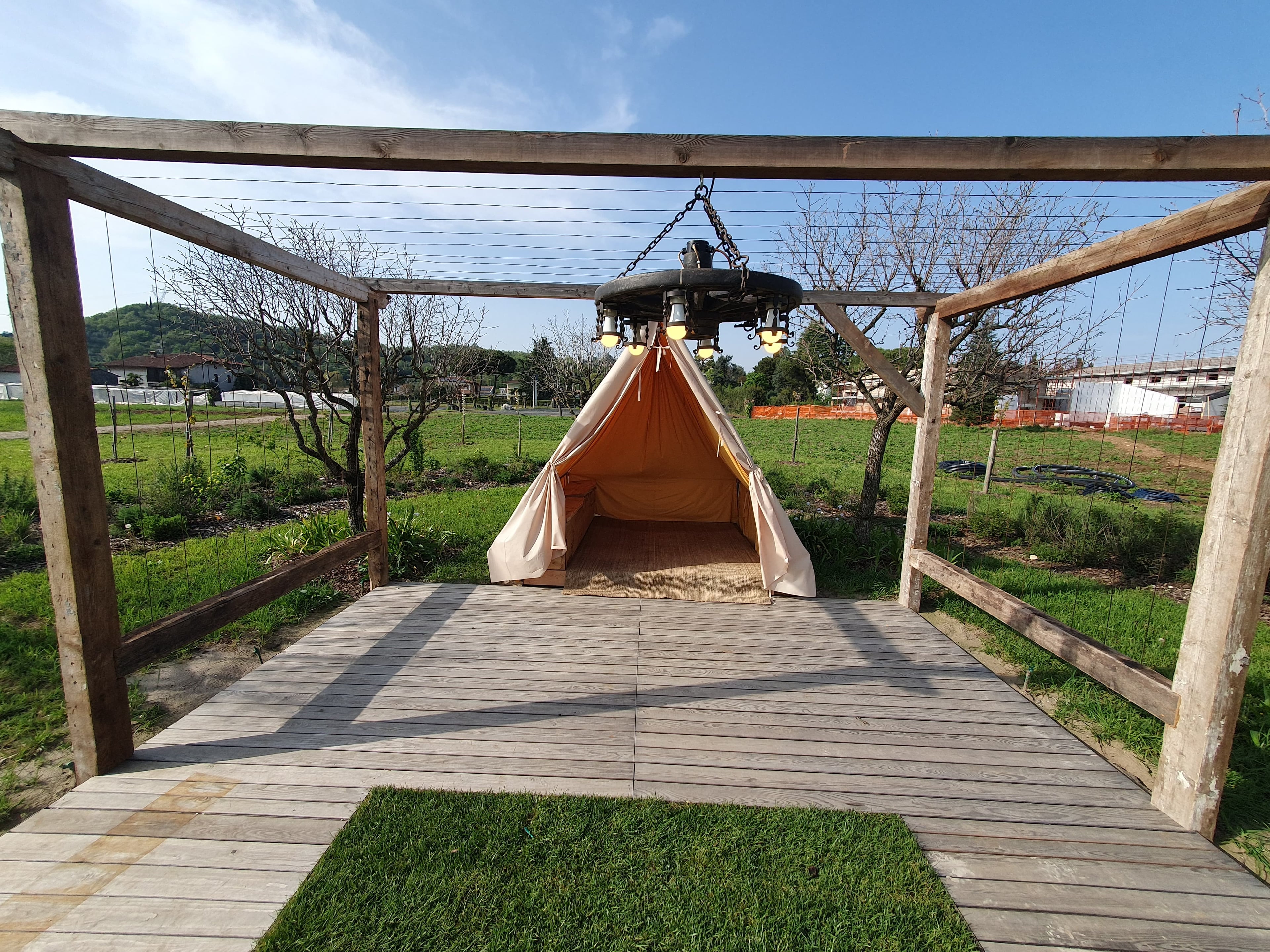 Gazebo in legno con tenda tipi e lampadario rustico sospeso, installazione elettrica esterna OBA Energia
